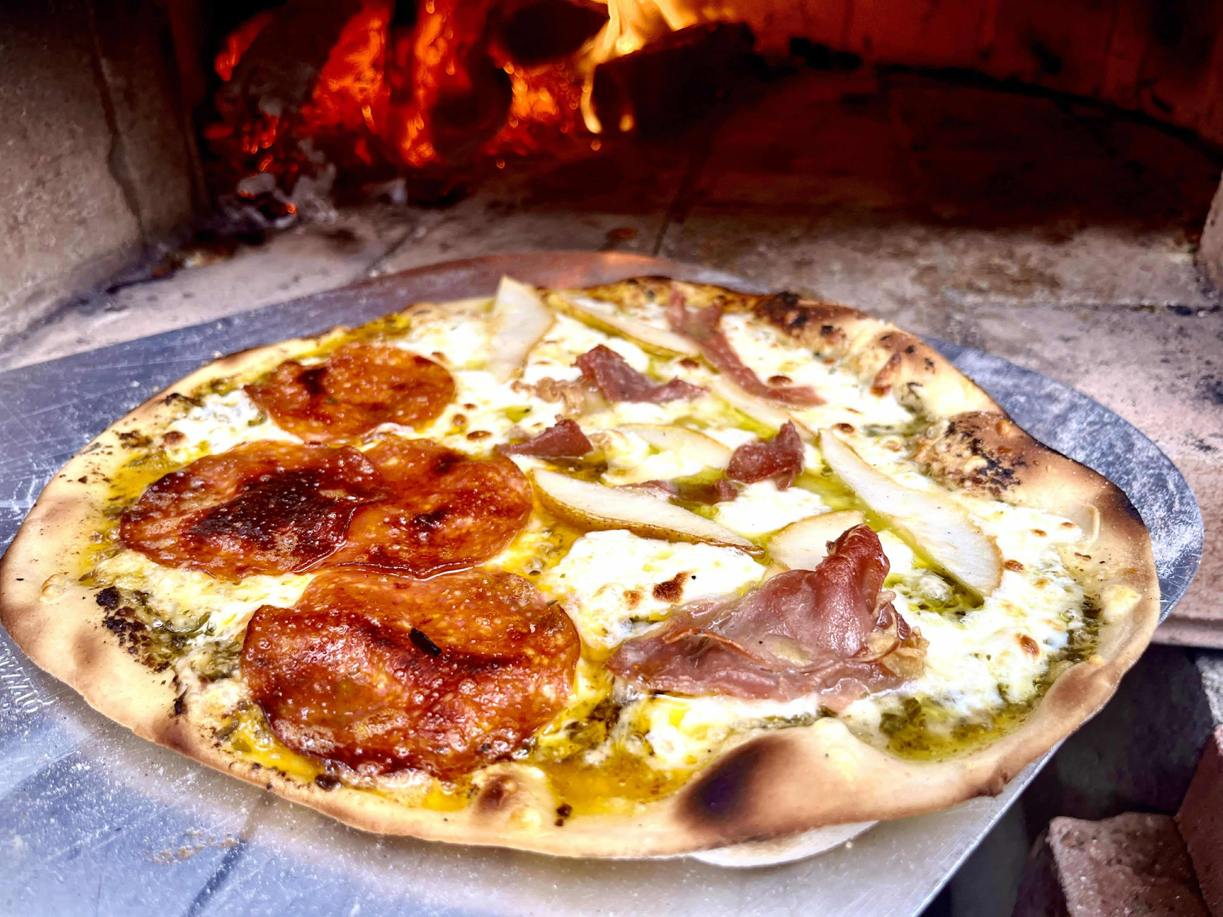 Pizza getting cooked in a pizza oven.