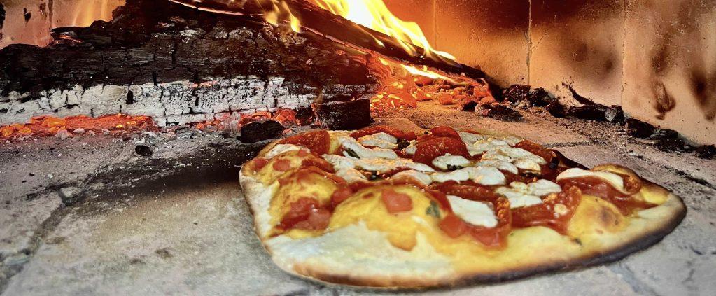 Pizza getting cooked in a pizza oven.